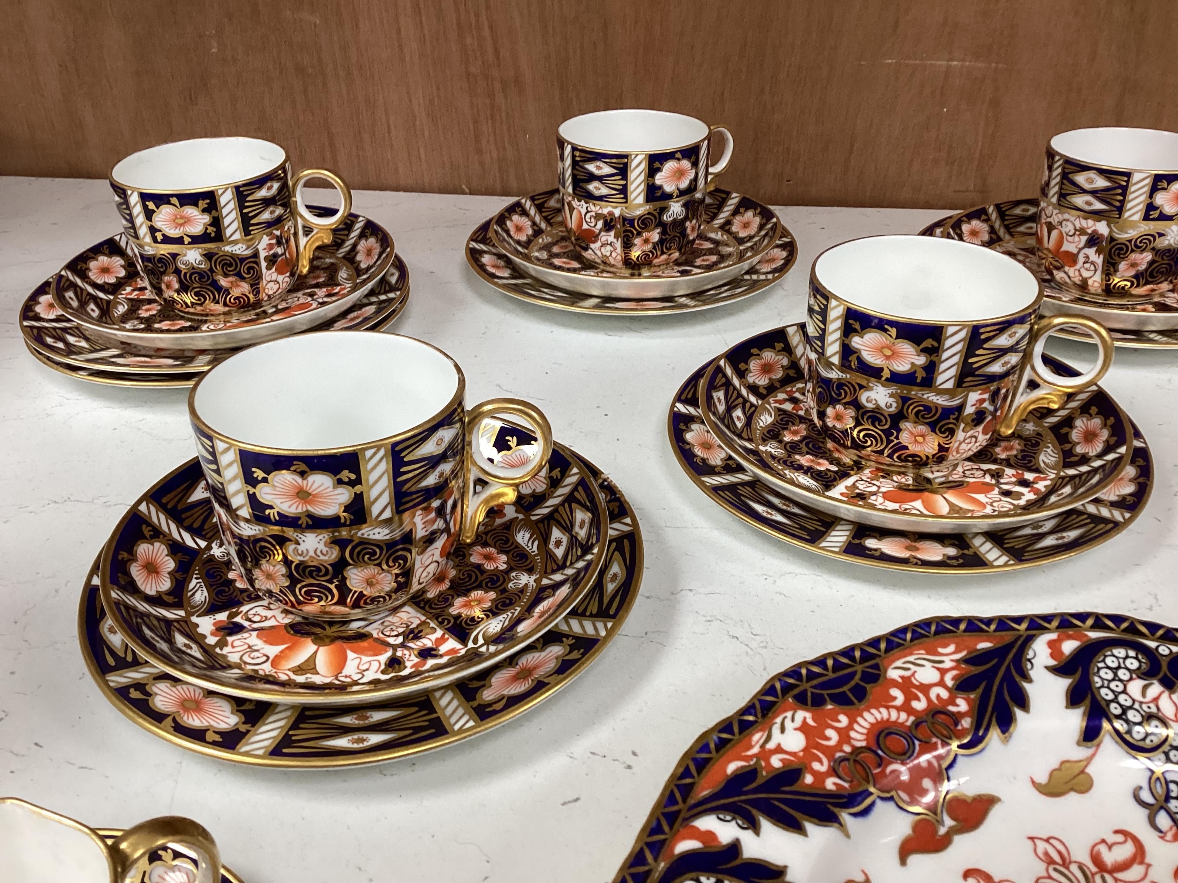 A Crown Derby Imari seven trio place setting, three other cups and two saucers, a large plate and a pair of Doccia- style vases, 18cm high
